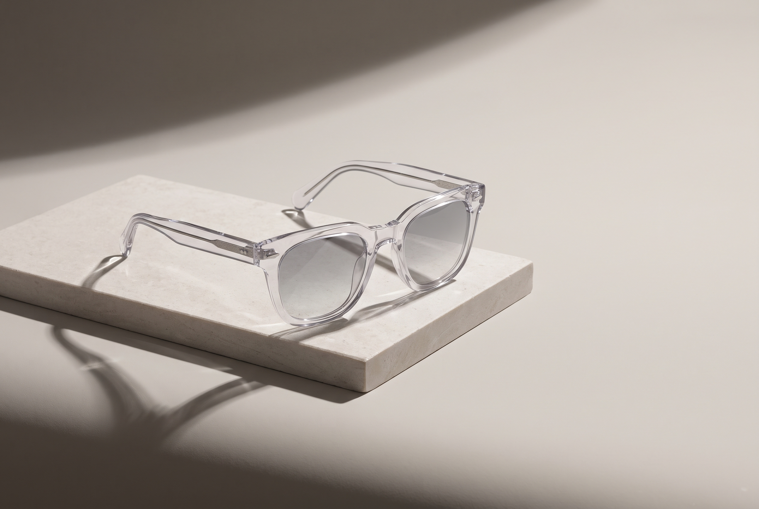 Crystal clear acetate Welham sunglasses on a pale stone plinth